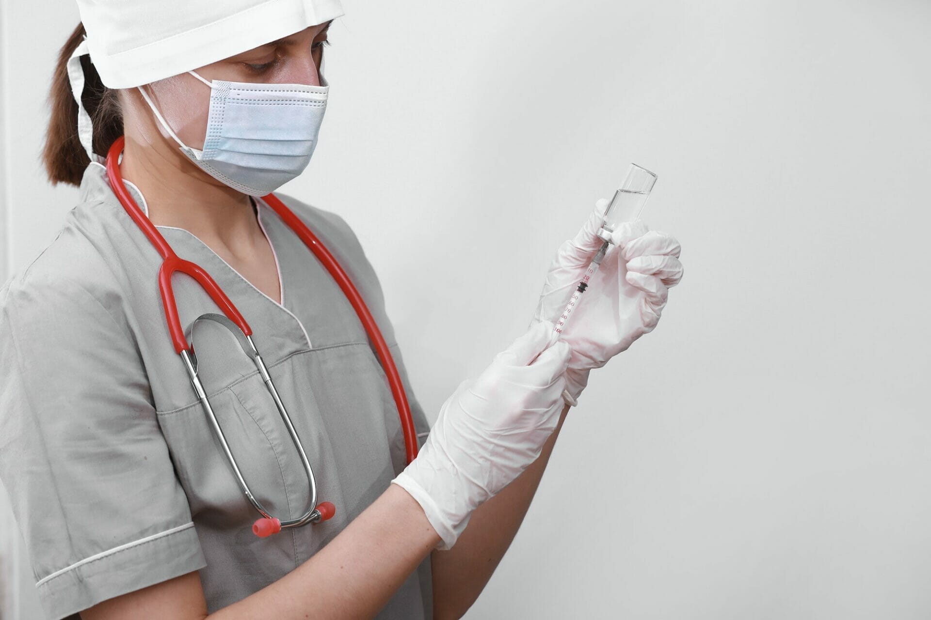 Doctor, nurse or scientist hand in white medical gloves holding flu, measles, coronavirus vaccine