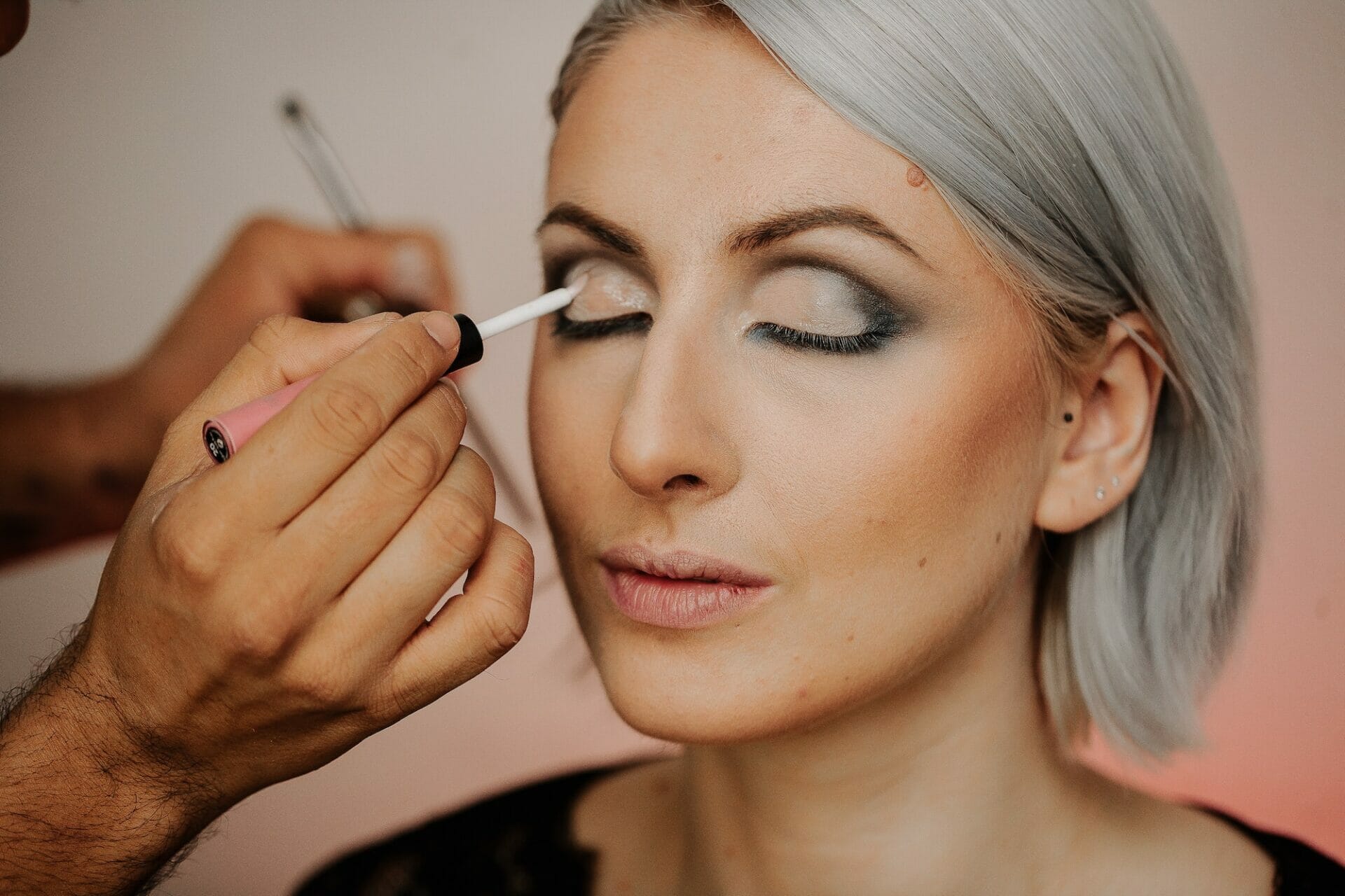 Makeup applications on the eyes of a woman with gray hair