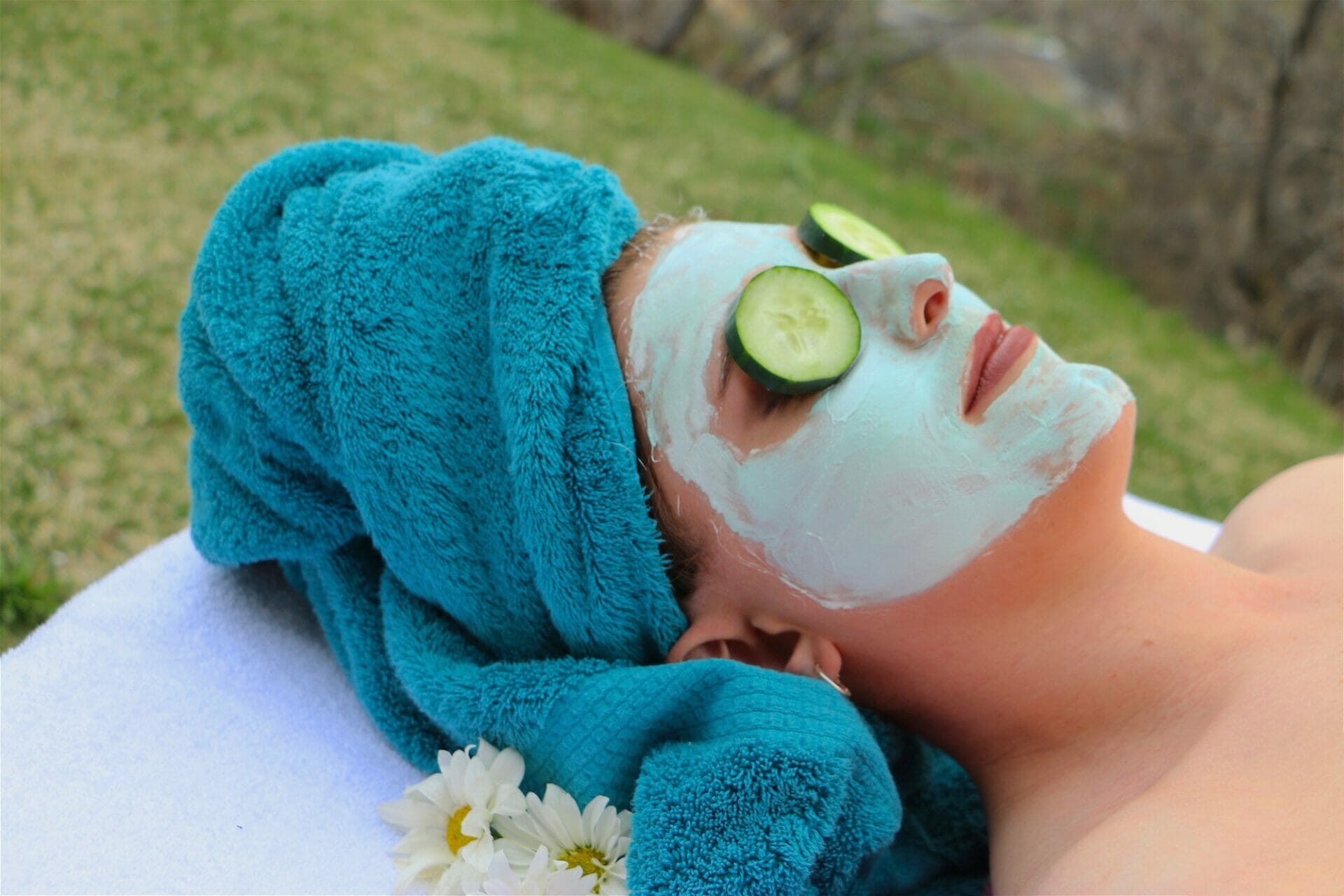Woman getting organic clay facial at outdoor spa.
